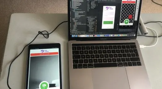 laptop with code on connected to a phone