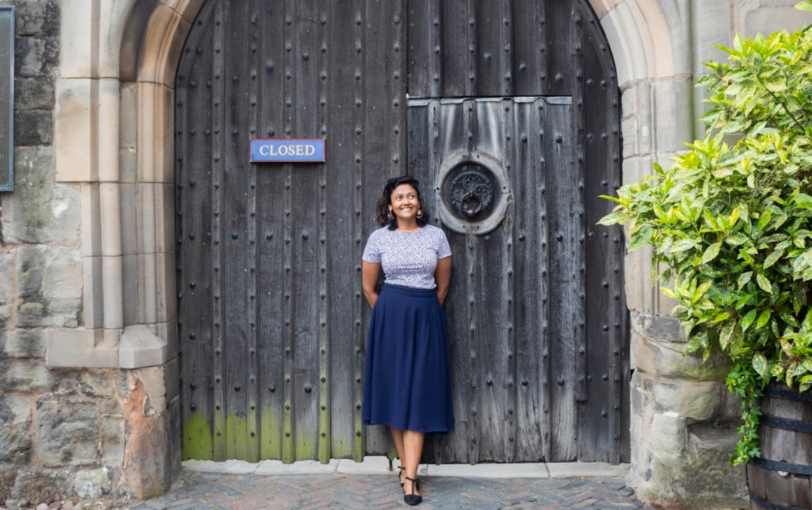 Samia stood in front of an old door smiling