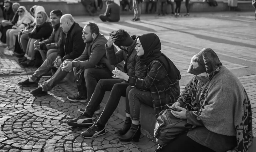 group of people sat on a curb