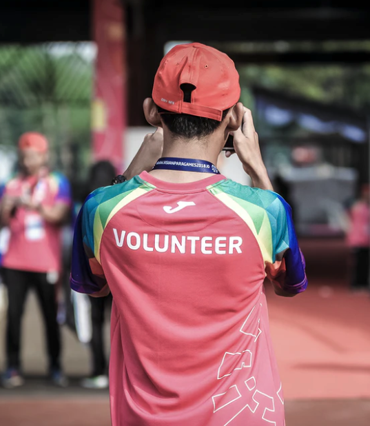 the back of a young person who has volunteer written on their shirt