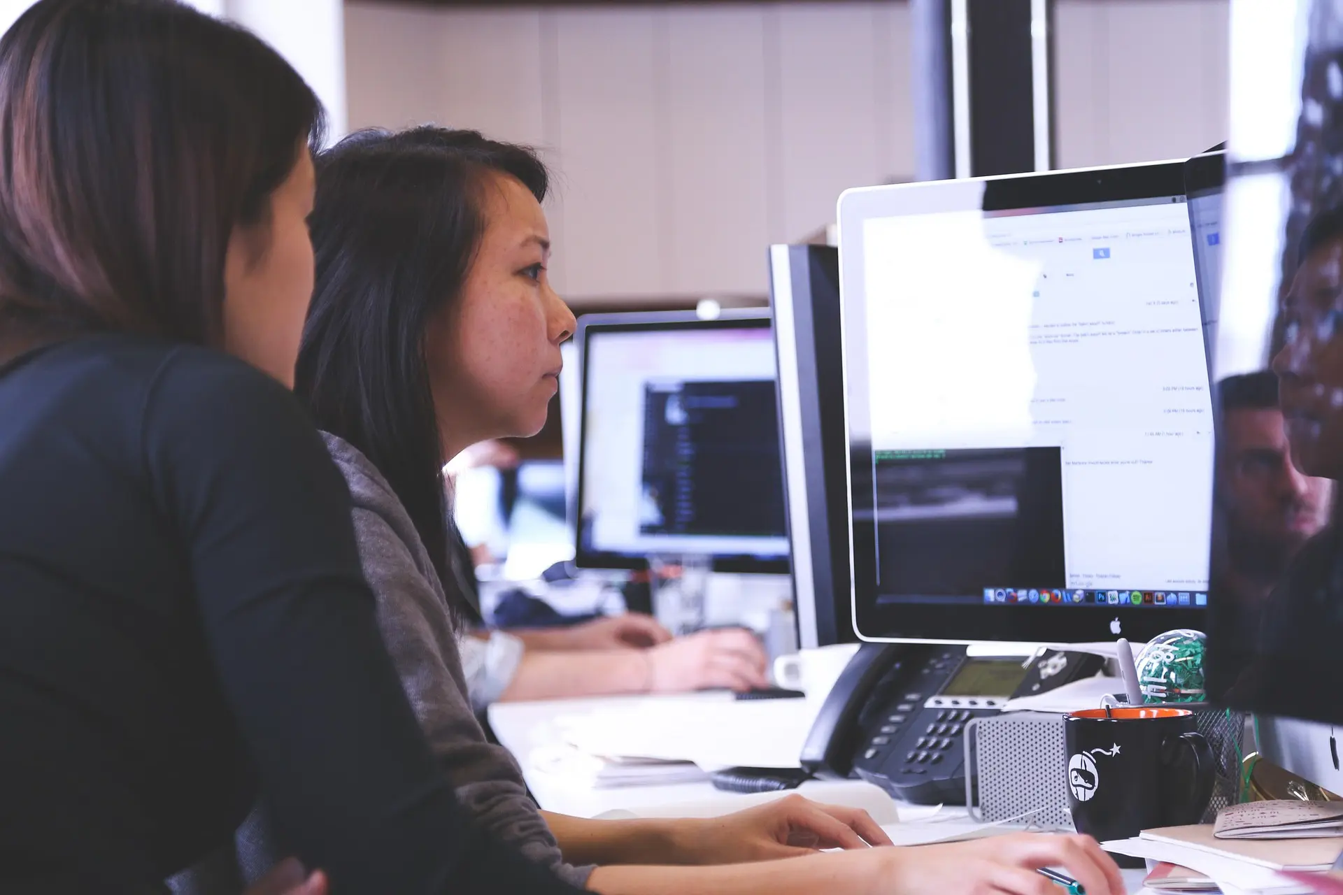 two women look at a computer screen