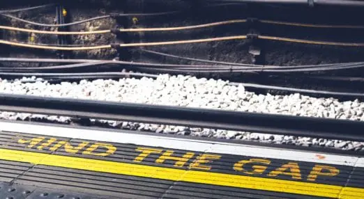 mind the gap sign on the floor of a train platform