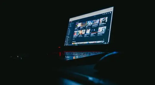 laptop in the dark with YouTube open