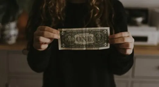person holding a dollar bill