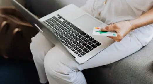 woman holding credit card and laptop