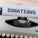 type writer with the word Donation on a piece of paper