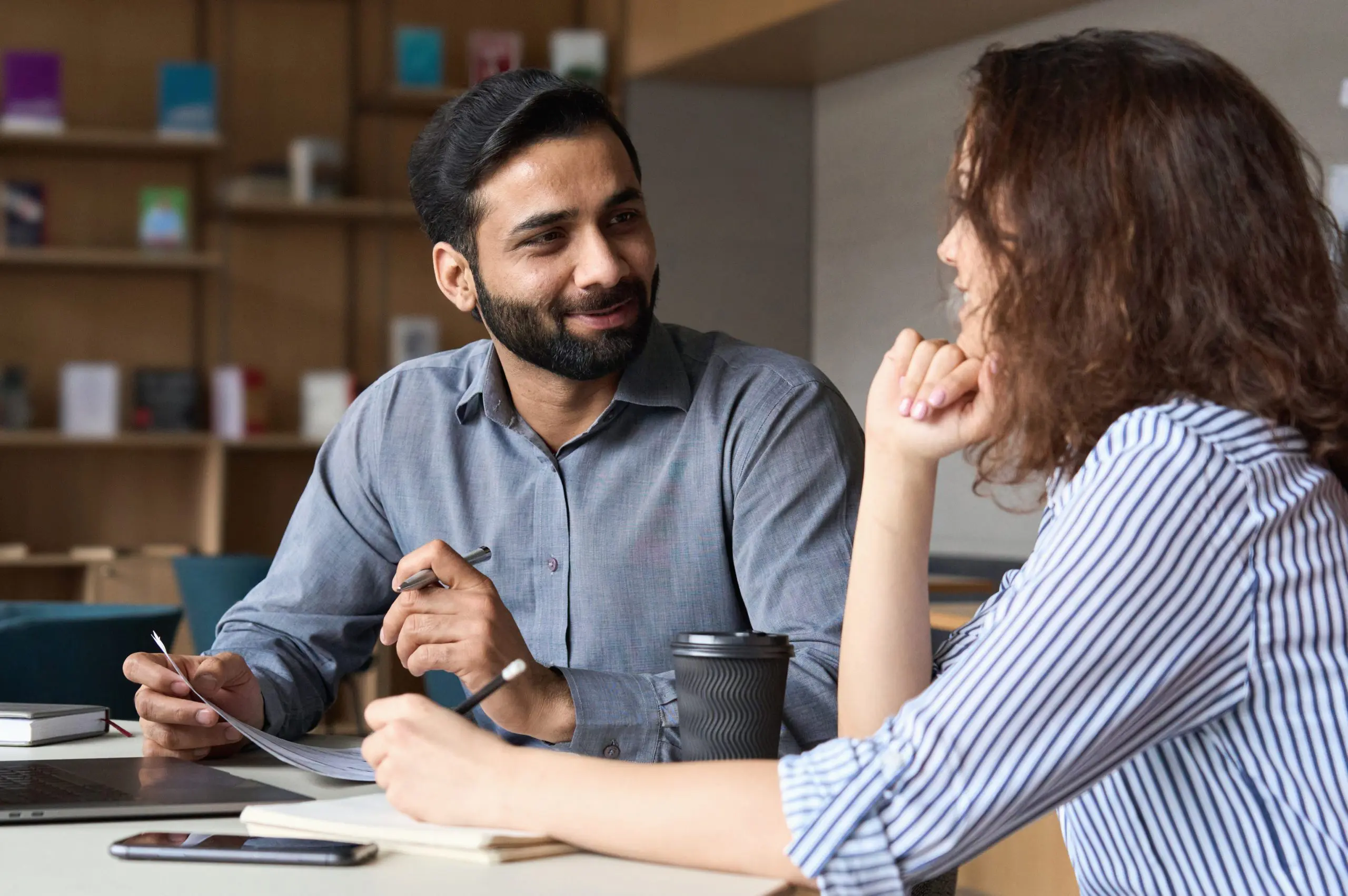 two people talking at a desk