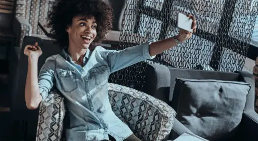 woman taking photo of herself on a couch