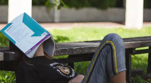 person lying on floor looking exasperated with a charity digital strategy document over their face