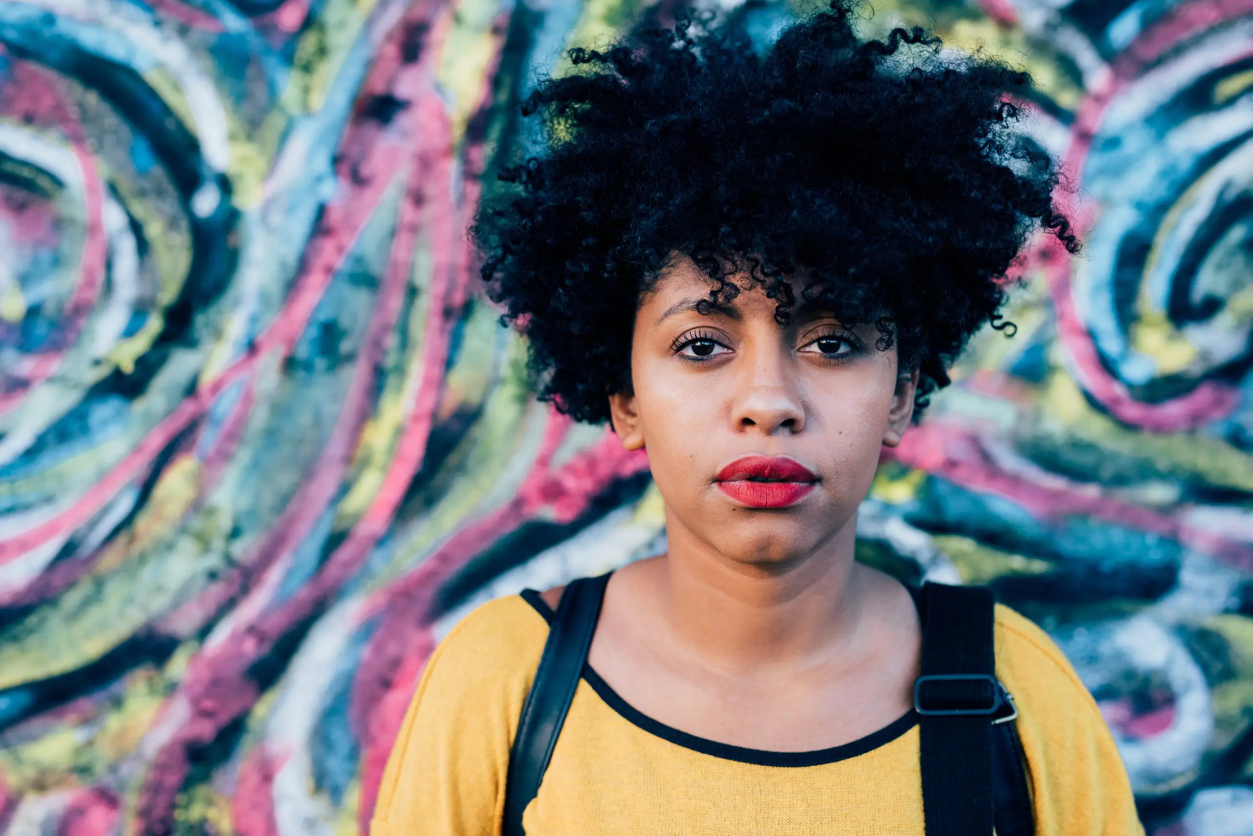 woman stood in front of graffiti'd wall