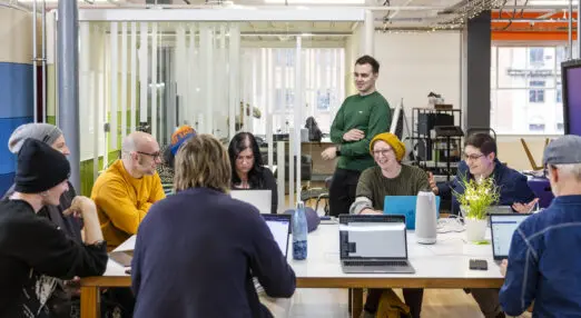 a group of reason digital's employees are standing and sitting around a table