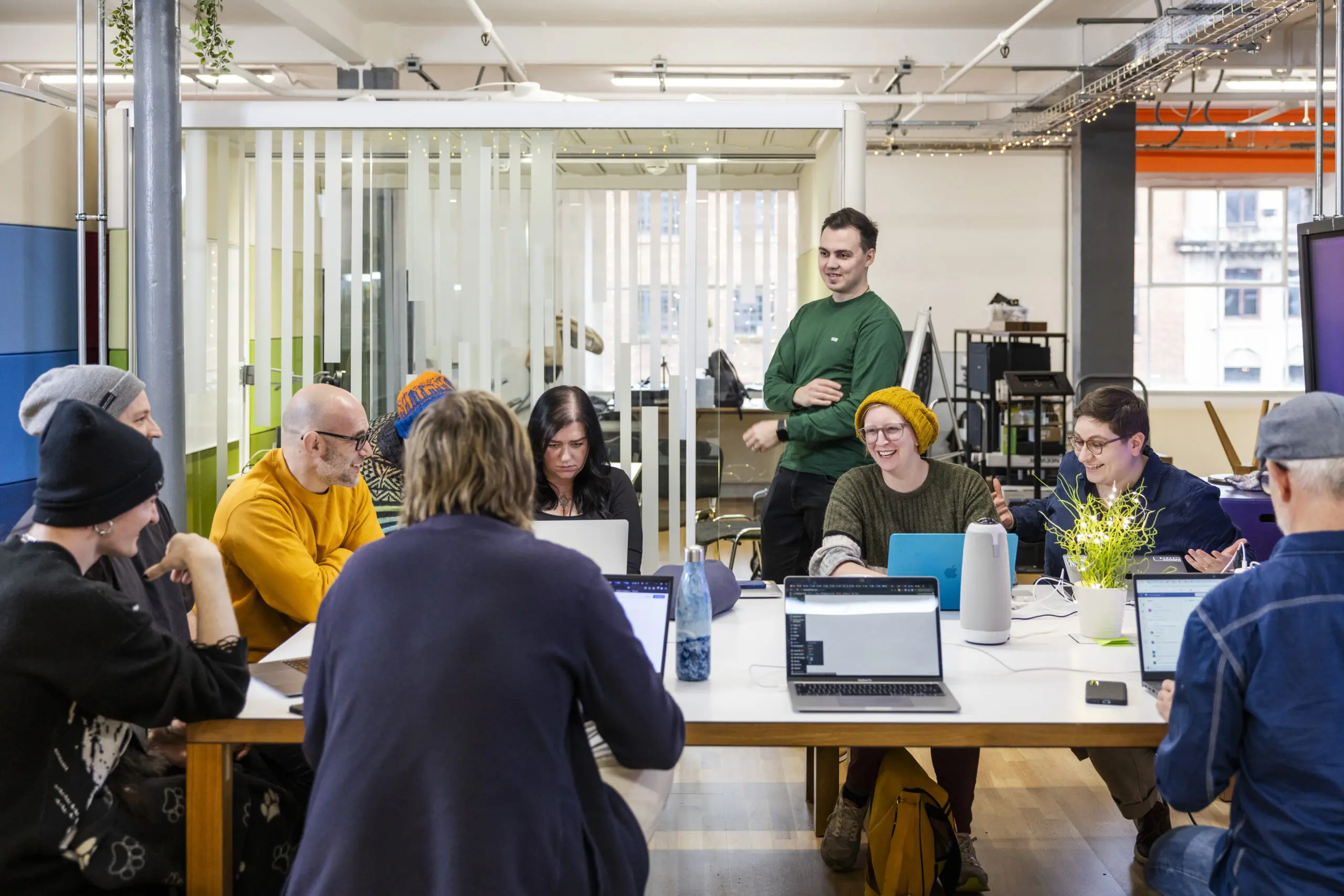 a group of reason digital's employees are standing and sitting around a table