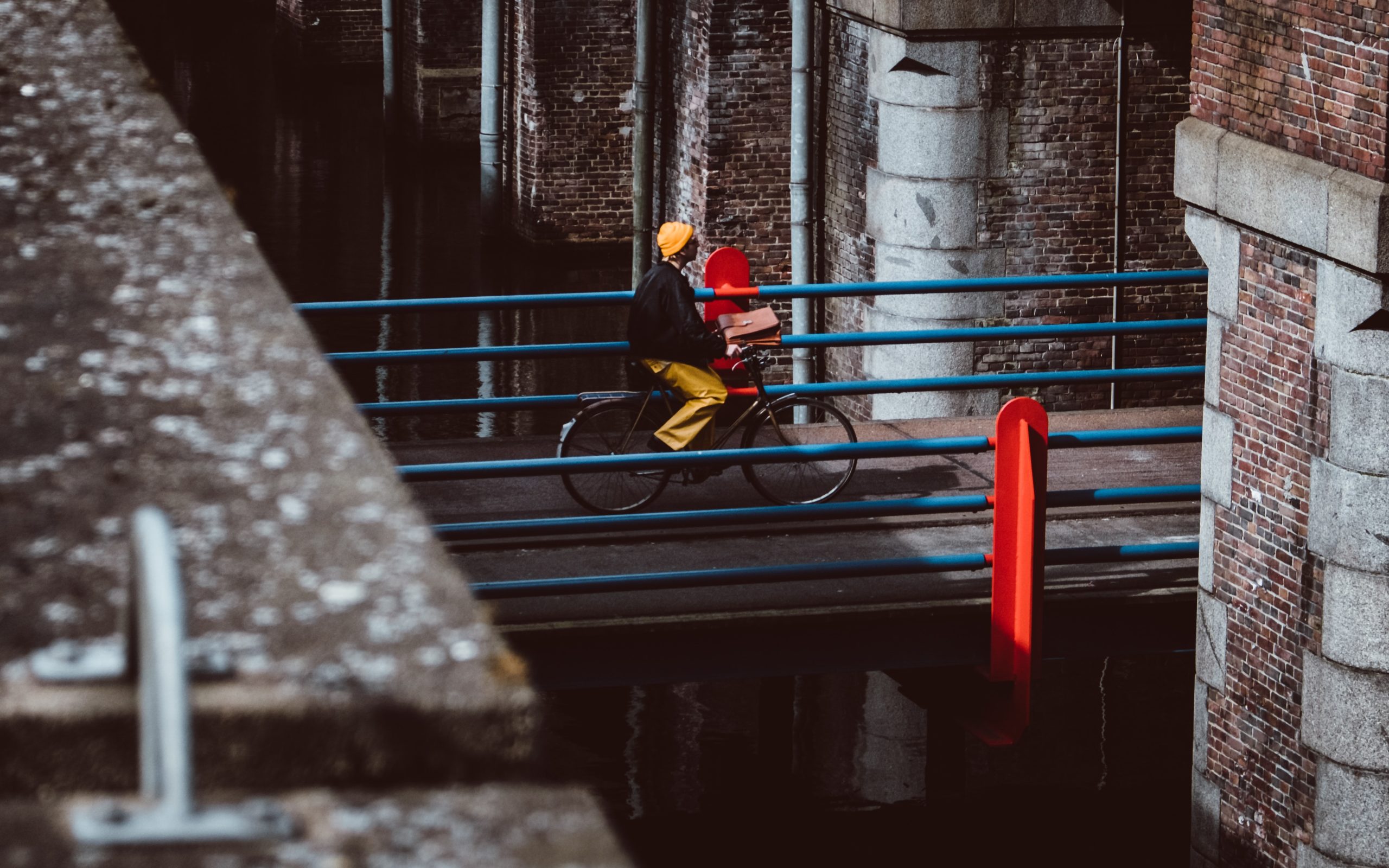 person cycling over bridge