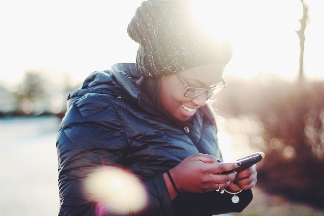 a woman smiling and engaging with content on her phone