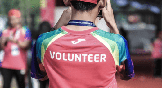 the back of a young person who has volunteer written on their shirt