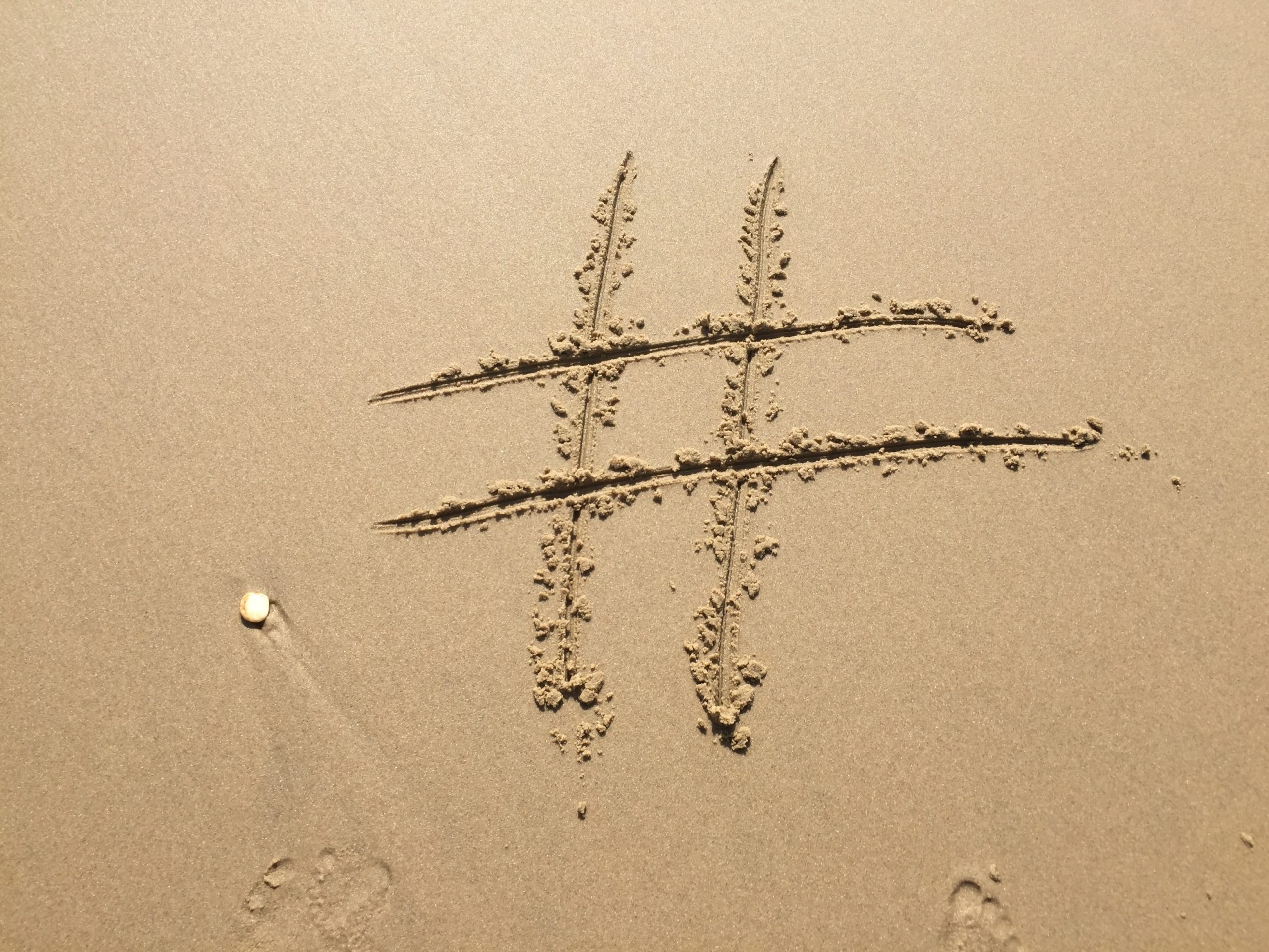 hashtag drawn into sand