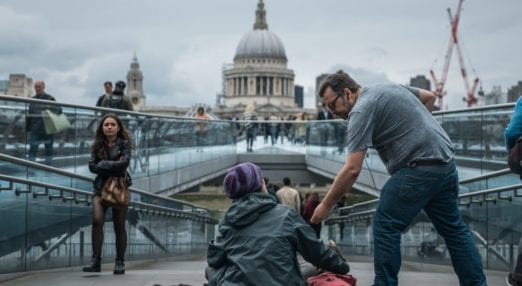 person giving a homeless person money in London