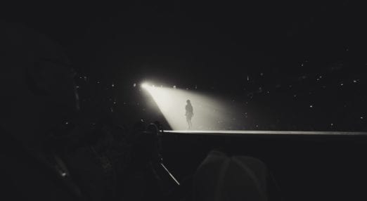 a spotlight illuminating someone stood on stage