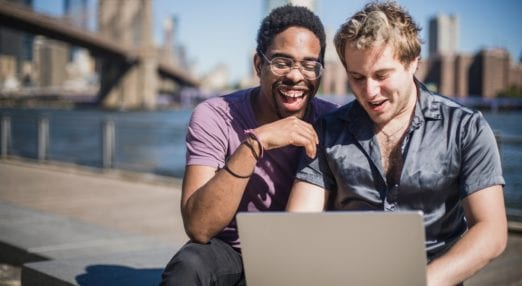couple smiling at a laptop