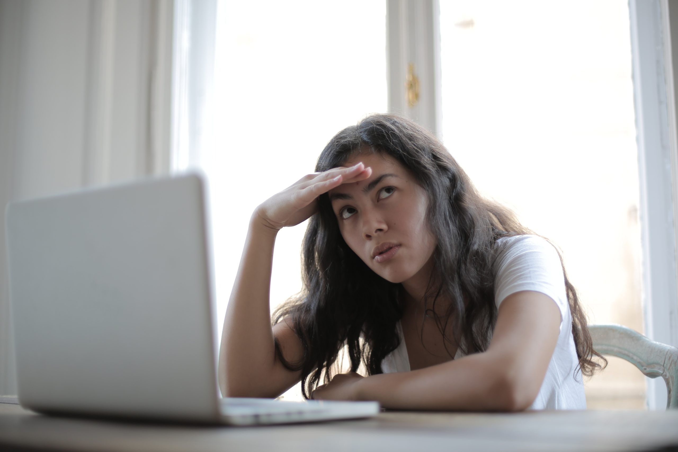 woman looking annoyed at a laptop