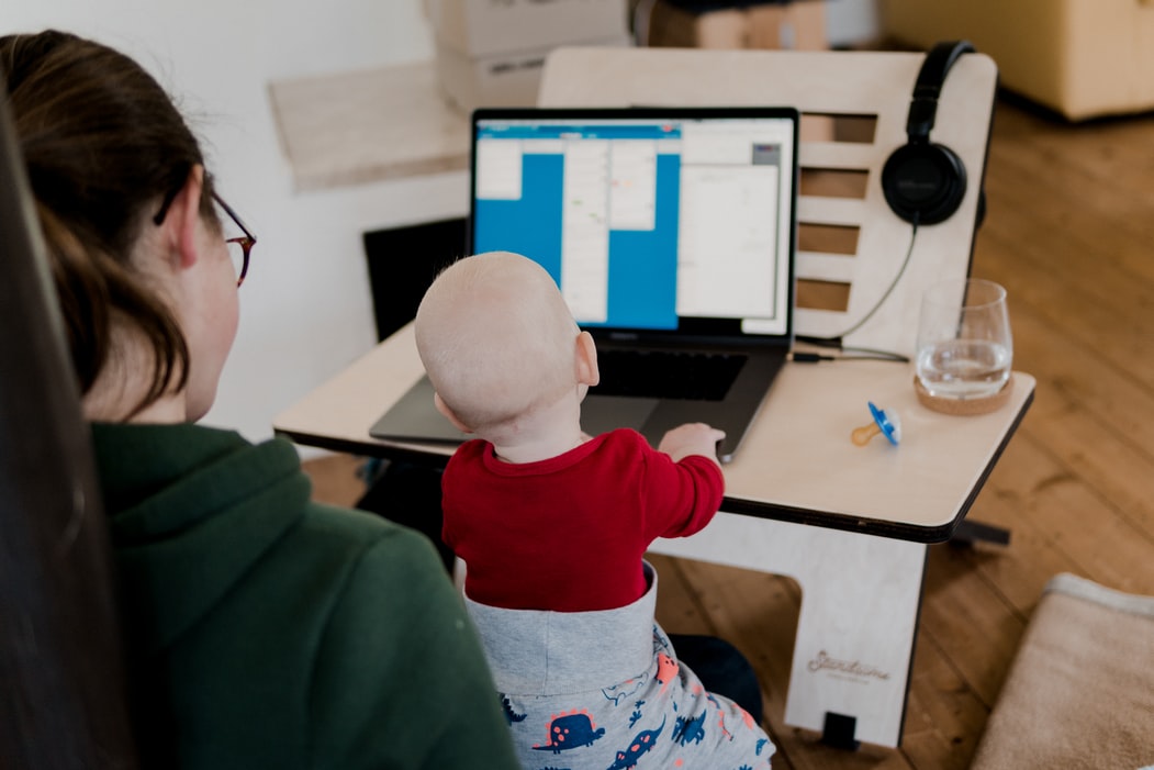 woman working on her laptop at home with baby