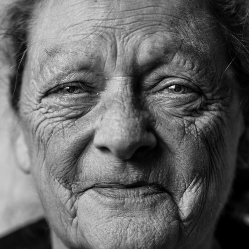 close up black and white photo of an older woman smiling