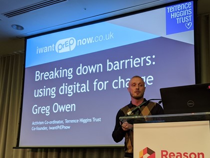Greg Owen standing in front of a display that says 'breaking down barriers: using digital for change'