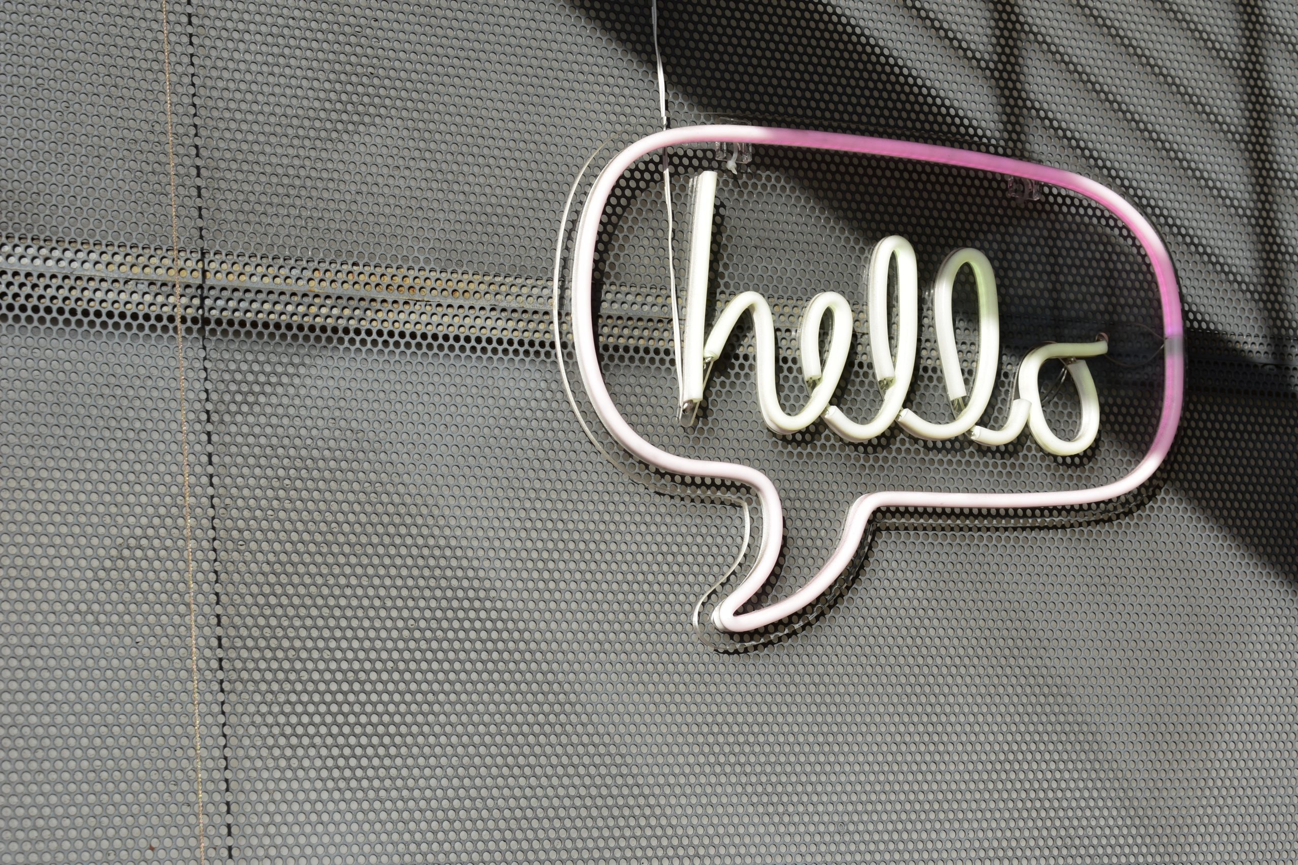 neon sign that says 'hello' in a speech bubble
