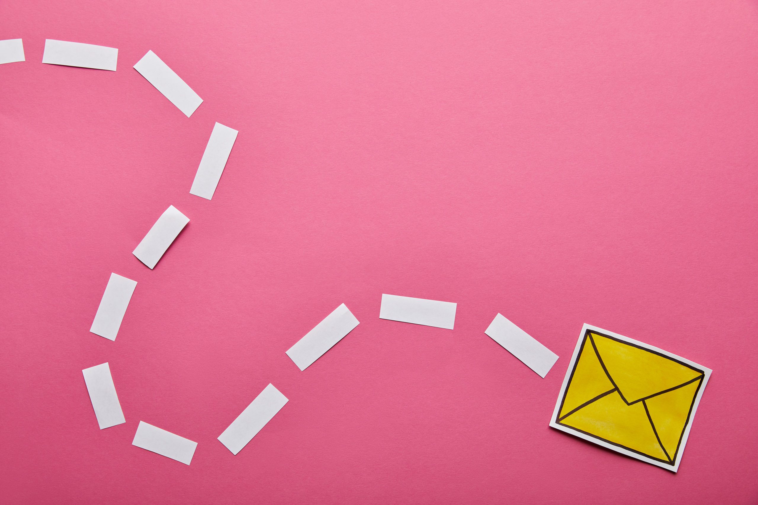pink background. a paper-made email icon travels across the background