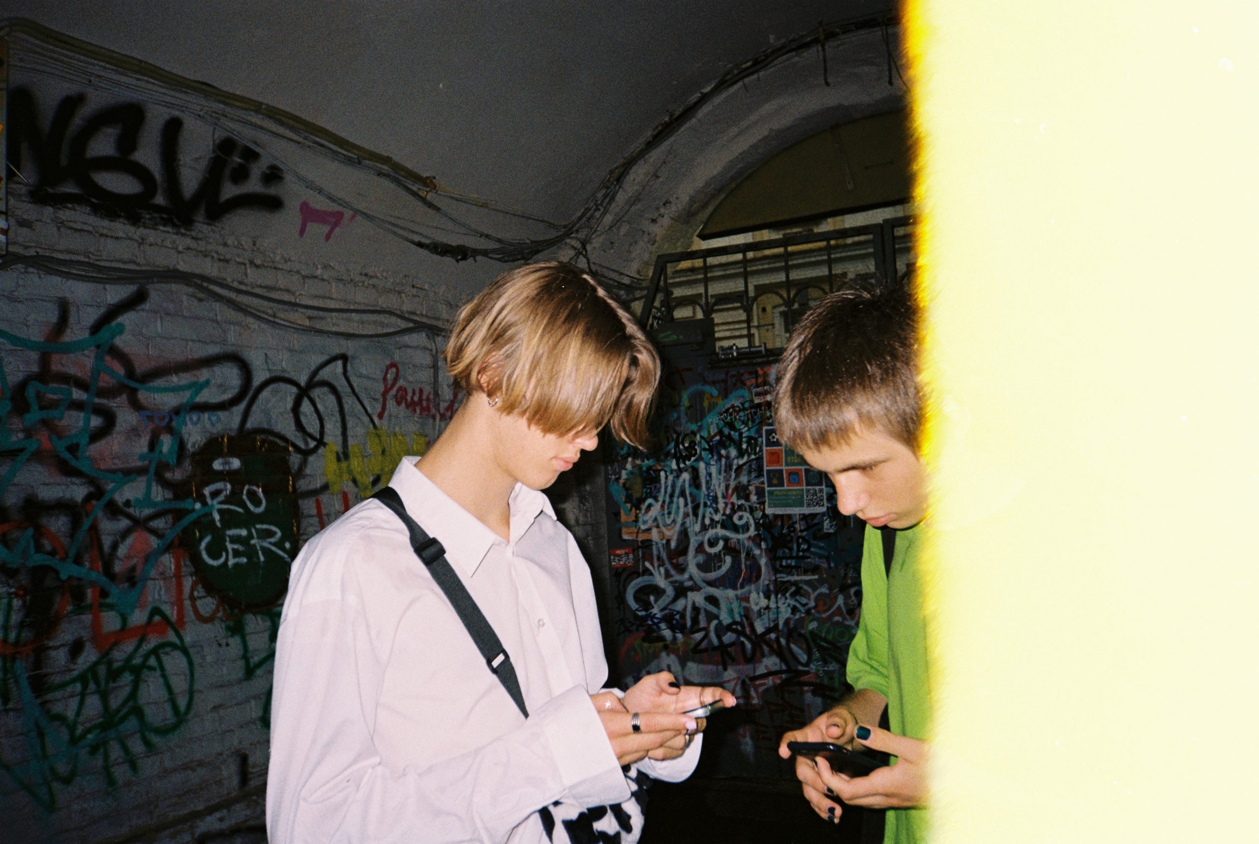 two boys in front of a graffiti wall