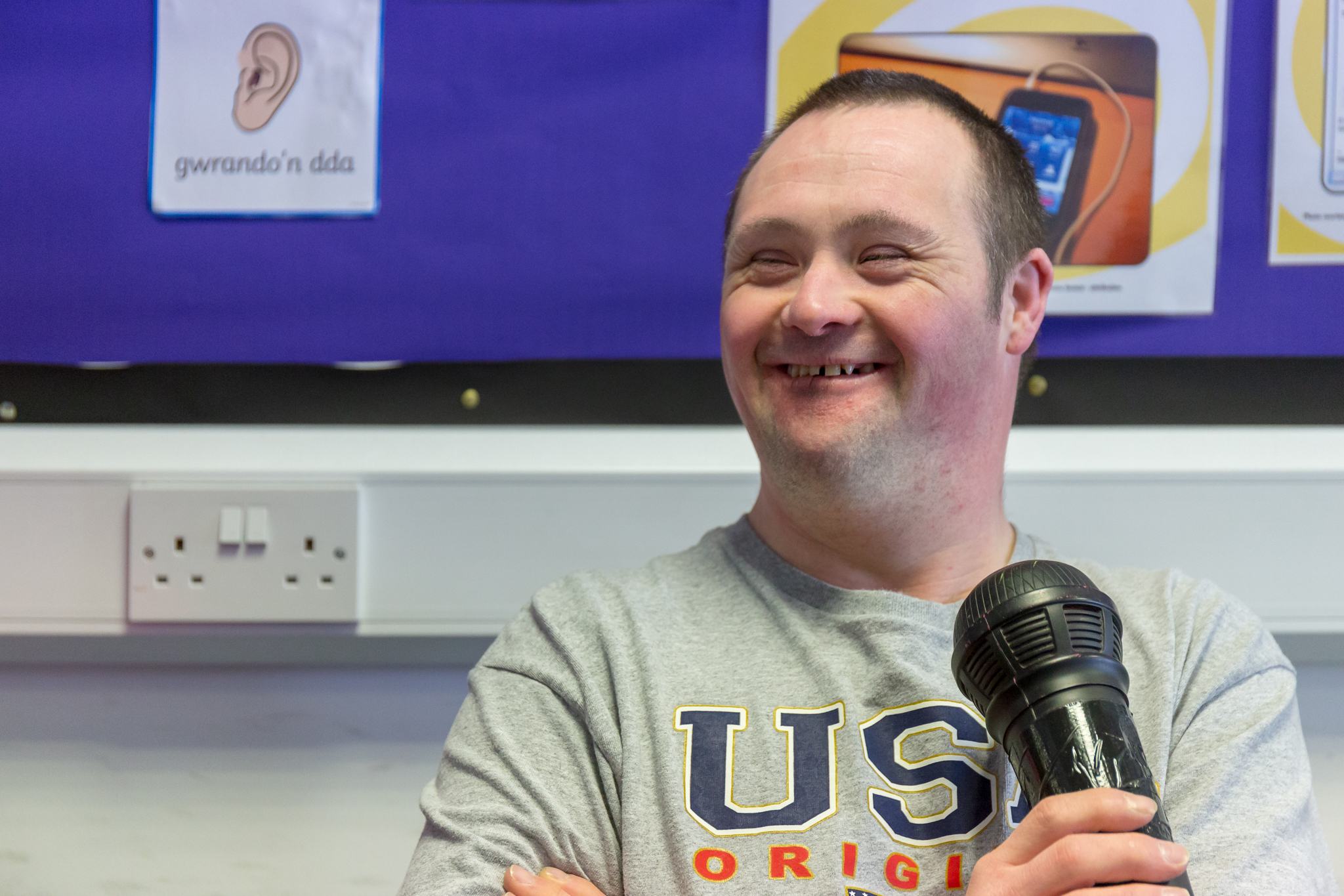 a man at the Leonard Cheshire centre smiling with a microphone in his hand