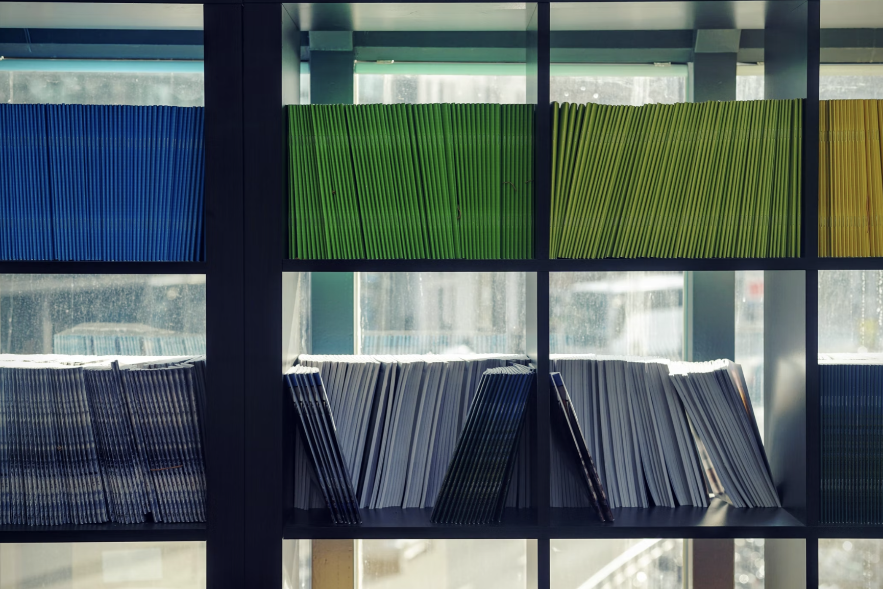 Shelves showing many coloured document folders leaning against each other