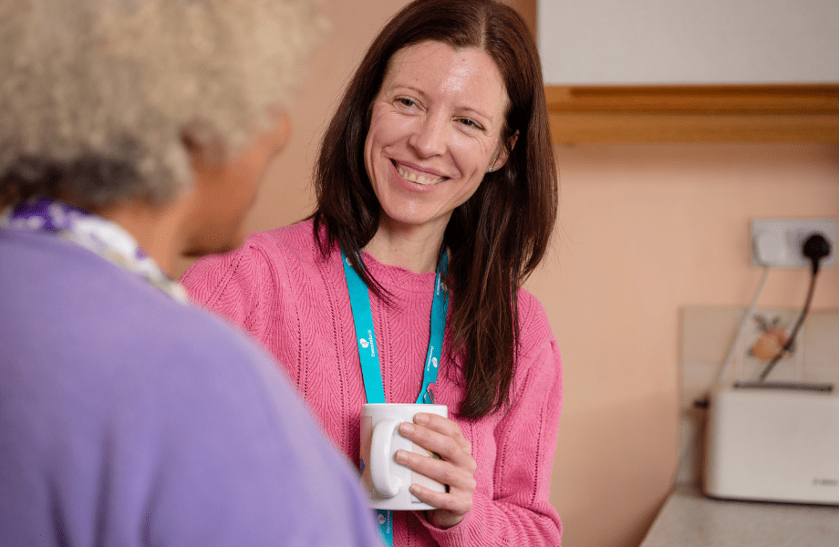 A woman with a lanyard listening to another women talk